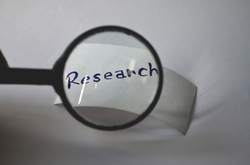 Lupe vergrößert das Wort "Research"